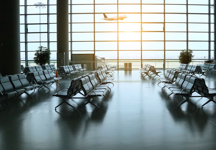 Airport gate waiting area empty with a plane taking off stock photo used by Woodruff Sawyer.
