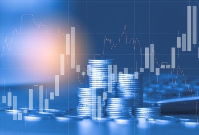Stacked coins with stock market activity overlay