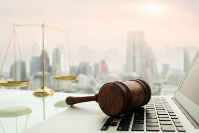 Gavel on laptop with city in background