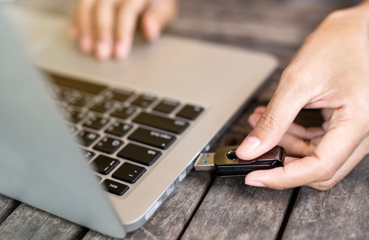 Hand inserting USB into laptop