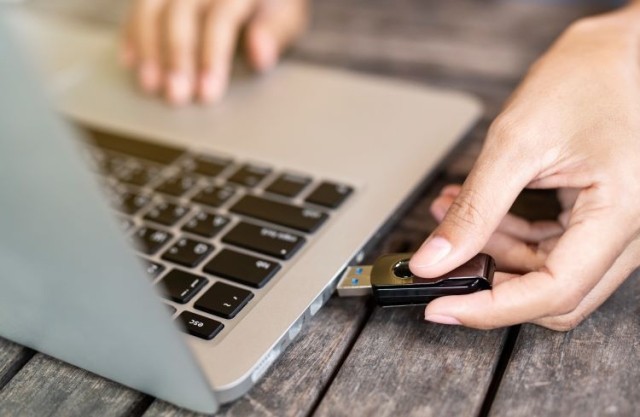 Hand inserting USB into laptop