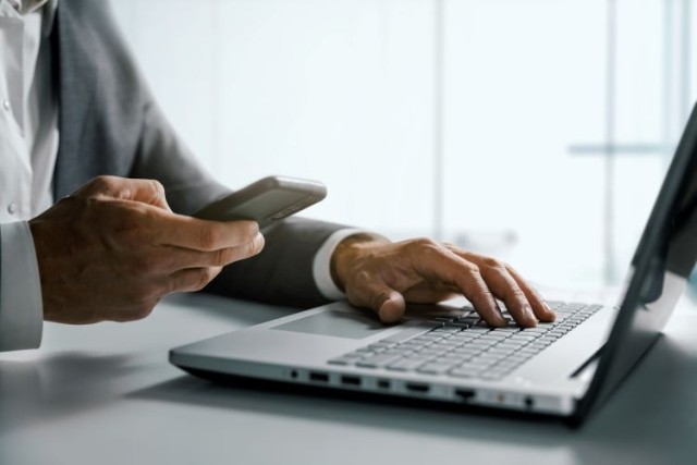 Business man working on laptop and mobile device