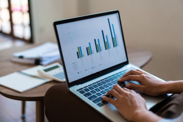 A person sitting at a desk with a laptop computer, focused on work