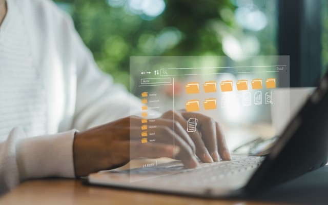 person on laptop looking at folders 